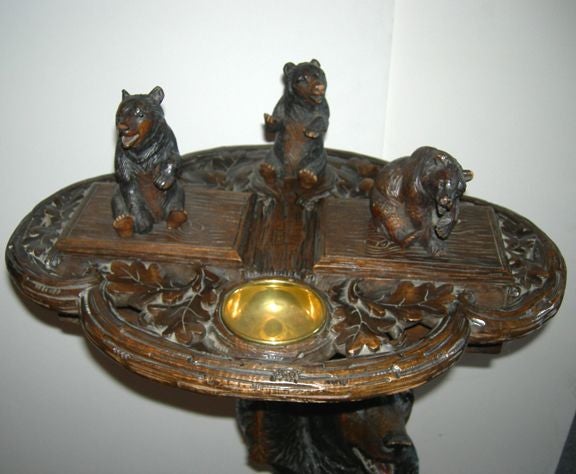 This fine example of Swiss Black Forest carving is a great bear holding up her little cubs. Two of the cubs are hinged boxes, while the center bear is a pipe rest. The large bear has a hinged head for tobacco storage. The carving is of the highest
