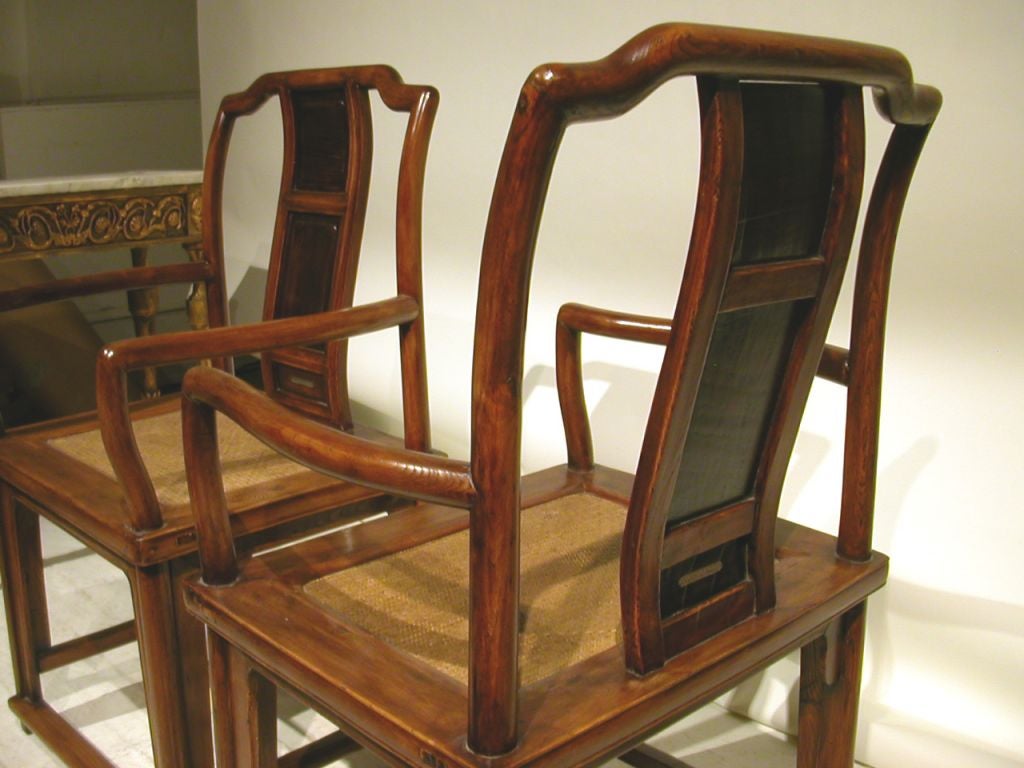 Pair of Chinese elm armchairs with cane seating.