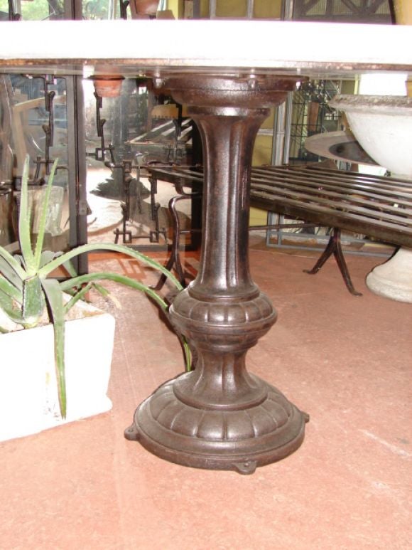 Round travertine top dining table w/ cast iron pedestal