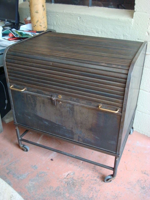 Steel tambour roll top filing cabinet on wheels, brass handles, orginial lock and key.