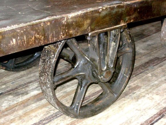 Un carro industrial metálico sobredimensionado procedente de una fábrica de armas de la Primera Guerra Mundial.  Hermosa superficie.  Perfecta como mesa de centro, como cama auxiliar de piscina o puede transformarse fácilmente en un sofá fijando
