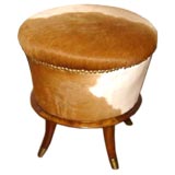 One French upholstered cow hide stool with brass feet.