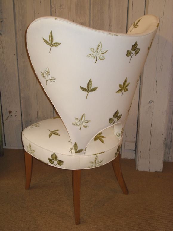 A pair of large scale 'butterfly' form modern wing chairs, upholstered in an overall embroidered leaf design fabric.