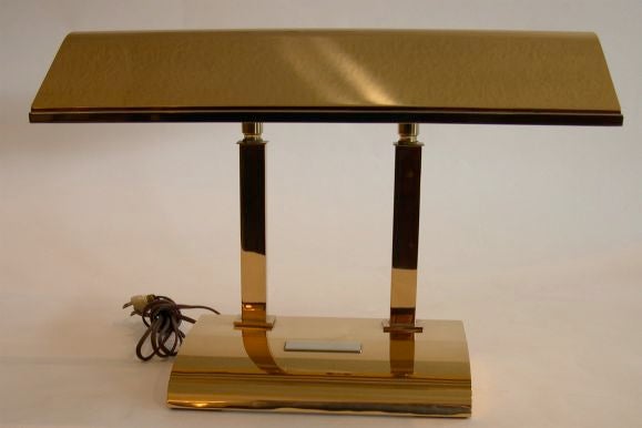 This sleek desk lamp is made of bronze with silver trim around the edge of the shade and on the plaque of the base, hence the name Silvercrest Bronze. The shade moves forward and back to adjust the angle of the light on the desk surface. It is