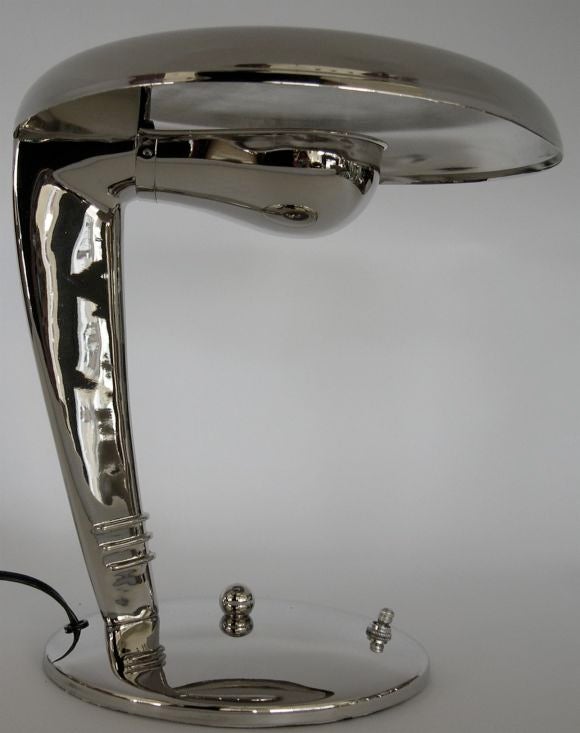 This sleek classic lamp has been restored in a beautiful polished nickel finish. The light bulb is hidden by the reflector shade which causes the light to shine upward and reflect downward from the underside of the top. This lamp gives off a strong