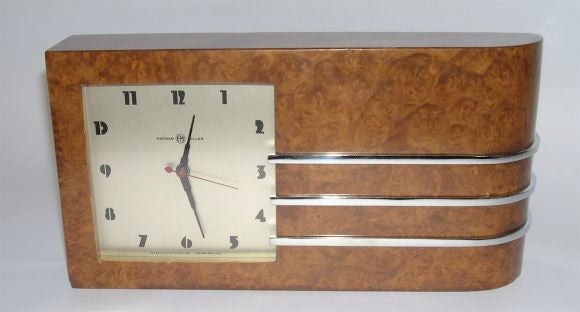 This is one of the largest and most streamlined of Gilbert Rohde's clock designs for Herman Miller. An ultra modern face is surrounded by a beautiful walnut burl case accented by three chrome stripes. It is excellent.