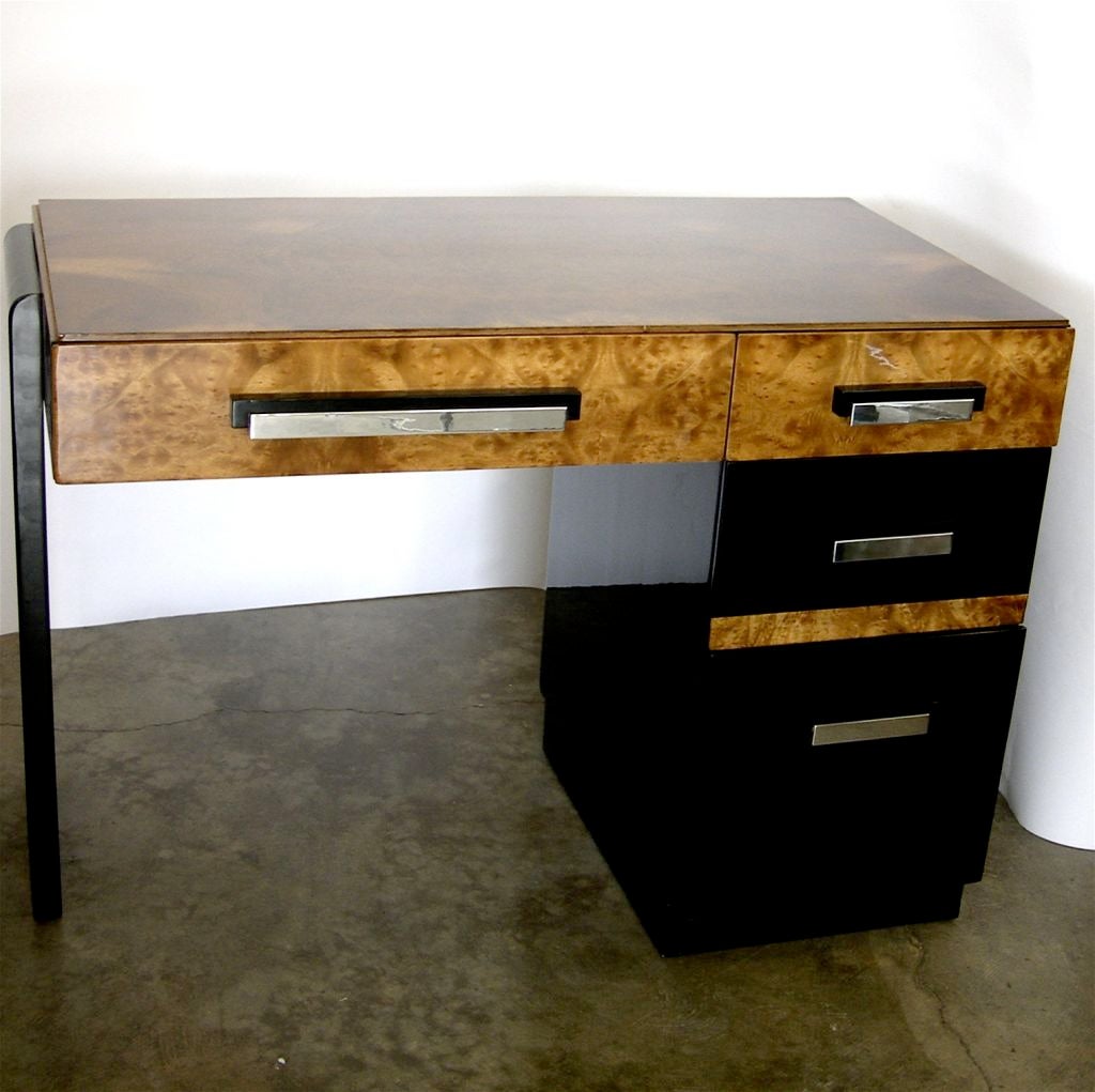 This rare desk is absolutely stunning. It has fabulous modern details with a beautiful hand polished high gloss lacquer finish. The combination of rich burl walnut, polished aluminum handles and black lacquer creates a very exciting and elegant