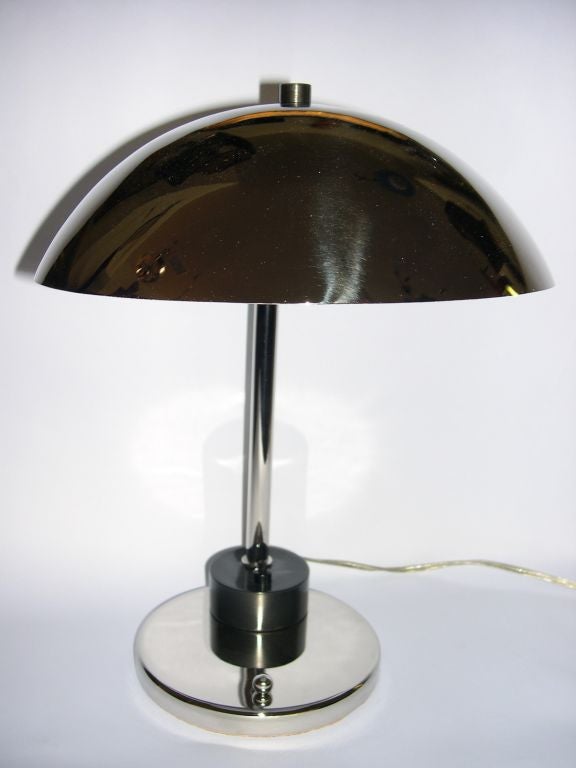 This very difficult to find lamp was designed by Kurt Versen. It has great lines and very modern, almost Bauhaus details. It has a polished nickel finish with black chrome accents. This lamp is pictured on page 381 of 