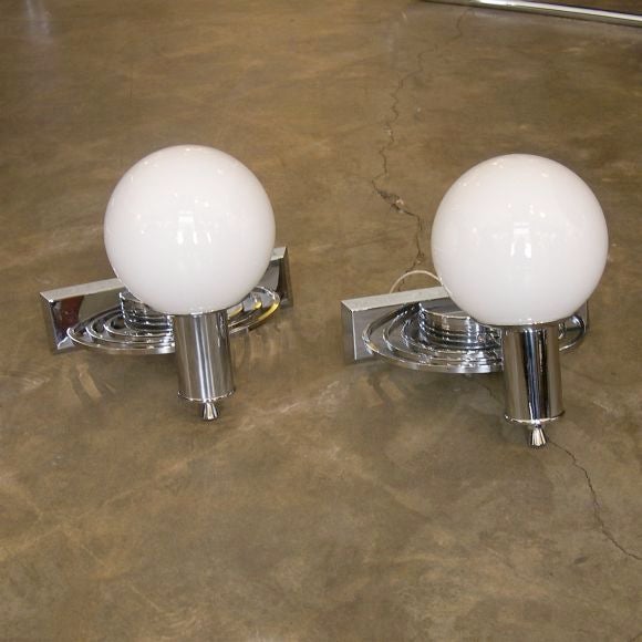 We have 2 pairs of these wall sconces available in case you need multiples. They are sold by the pair. They are chromed metal with glass ball globes. They can hold up to 60 watts each and give a beautiful soft light.
