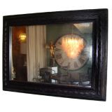 ANTIQUE MIRROR WITH EBONIZED HAND CARVED FRAME