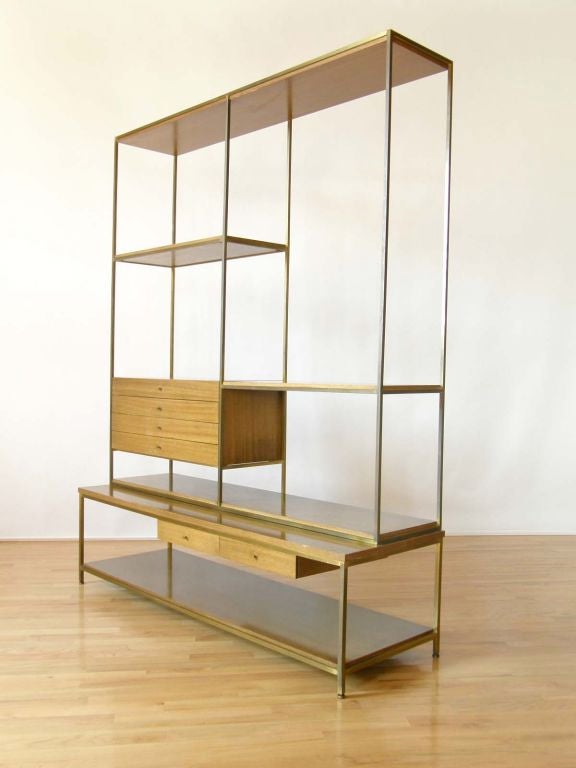 These display shelves are finished front and back, so they can be used in the open or as a room divider. Six slender drawers provide storage.