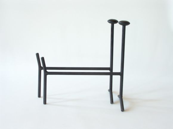 These andirons are from a series of fireplace accessories designed by George Nelson for Howard Miller in the early 1950s.