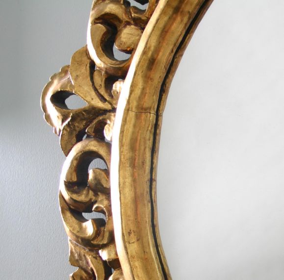 A fine Italian round mirror with detailed openwork carving.