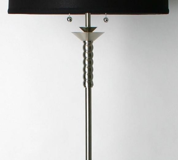 This is a simple and elegant floor lamp with a dull nickle plated.