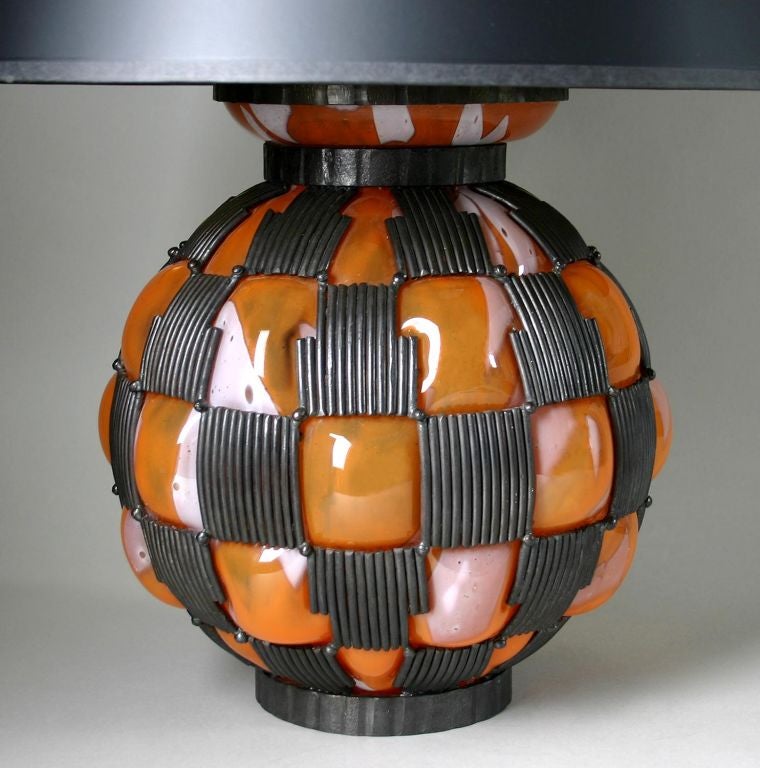 This is a stunning single lamp.  The color of the glass is a rich, rusty orange with white accents. The textured metal work is quite nice. Provenance Sotheby's Chicago