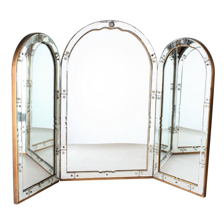 This is a wonderful example of a large three panel vanity mirror. The mirrored frame is beveled.  The wood frame is guilded on the edge.