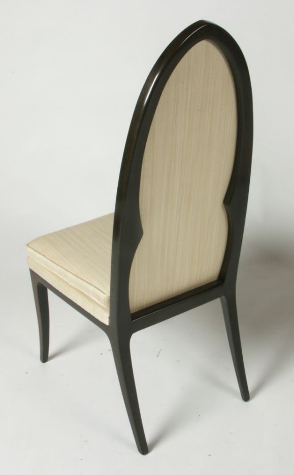 Pair of high arch back side chairs in dark mahogany with beige upholstery.