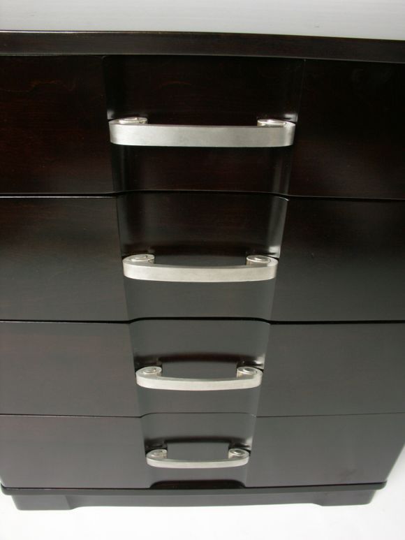 Matching pair of four drawer chests with silver plated scroll hadware. Chests with rounded corners and stepped in centre, dark brown finish on ash.