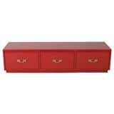 Low red lacquer chest of drawers in style of Tommi Parzinger