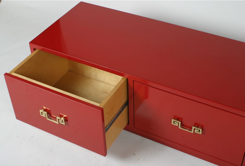 Low chest of drawer in high polish red lacquer with brass greek key hardware, 3 drawers with inset base.