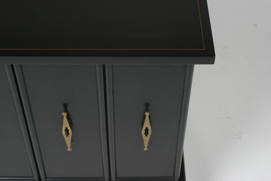 Black lacquer cabinet in original finish with brass pulls on bifold doors, top with gold pinstriped border