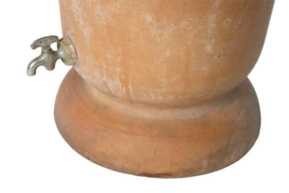 A two-part water filter and dispenser from Argentina with a brass spout.