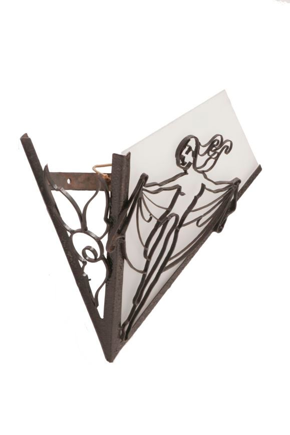 A French wrought iron Fer Forge sconce depicting a showgirl on the front and a floral motif on the sides, with a frosted glass shade, circa 1920.
Requires wiring.