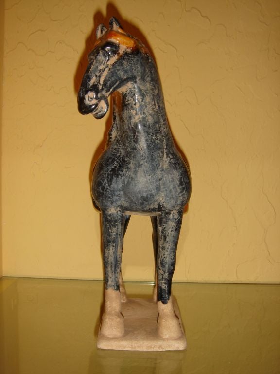A Chinese Tang style horse standing four square with blue glaze, saddle in green and orange glaze