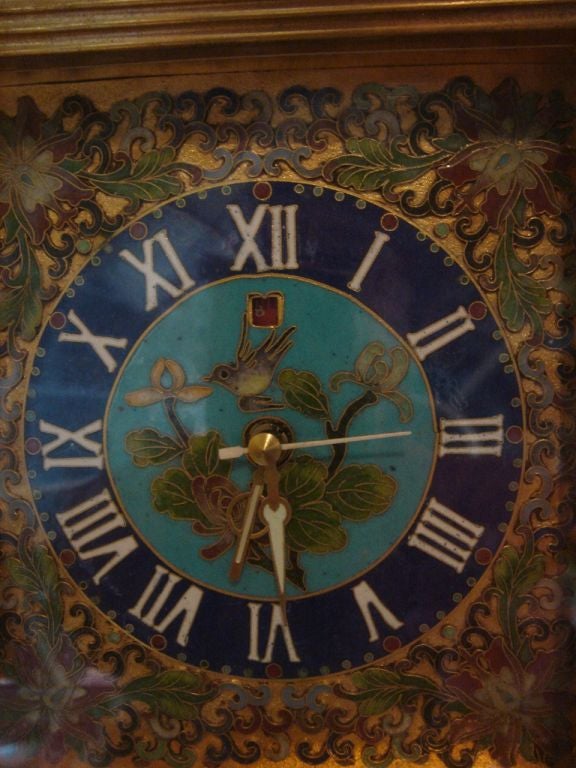 A Chinese imperial cloisonne and gold wash clock on carved wood stand