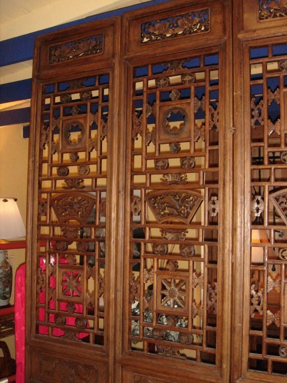A set of four tall Chinese poplar wood, hand carved screens from Shanxi Province