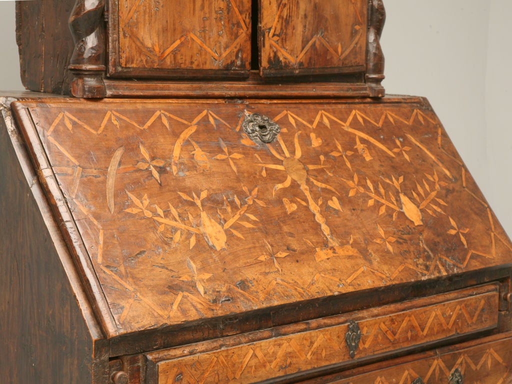 Handmade primitive Spanish desk with extensive inlay. We were told by a European antique expert that this piece is from the 1500's. It has beautiful hand-cut, crude barly twist columns and 7 hidden drawers inside. The top exterior drawer is faux.