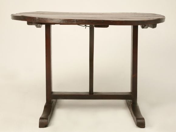 Rustic wine-tasting table made from fruitwood with a round tilt top. Handmade with a nice wide stretcher. Beautiful banded top.