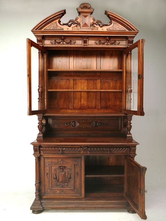 Renaissance Revival (Henri II) ornately carved walnut hutch with original wavy glass doors. Recessed panels with hanging and draping banners and scrollwork adorn the frieze. Flared leaf and hanging bellflowers detail the frieze. Fluted