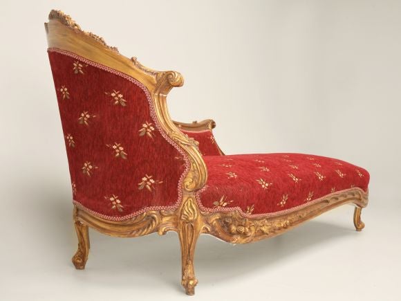 Rococo style gilded fainting couch with floral motif.
