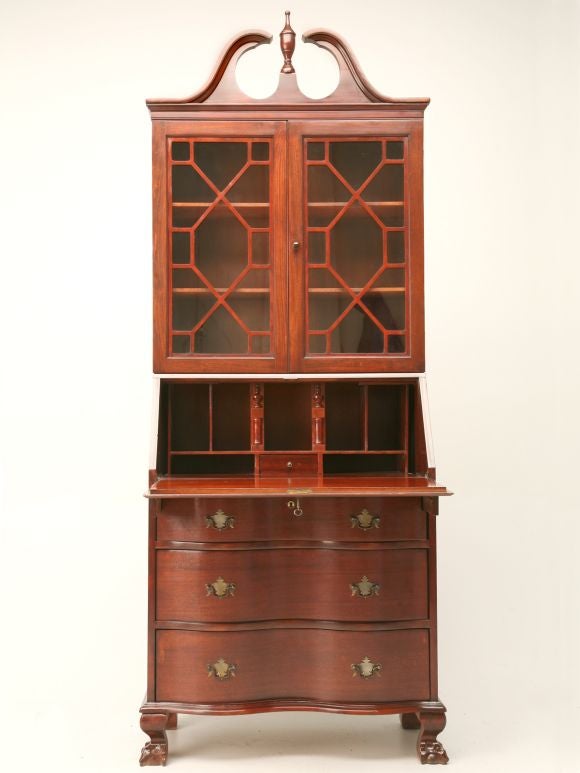 Petite Chippendale-style secretary bookcase made from solid mahogany with a nice pediment top, serpentine drawers, astragal glazed doors and original hardware.