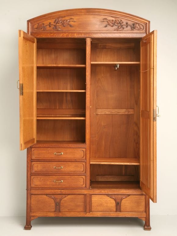 Art Nouveau chifferobe in oak with two doors and five drawers, original mirror, dovetailed drawers, original hardware and a beautiful leaf relief on the crown and a nice detail on the side of the crown.