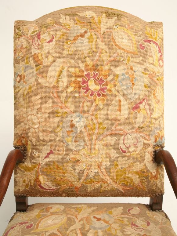 High-back throne chair in walnut with sweeping arms, scalloped apron, and lovely original needlepoint upholstery.