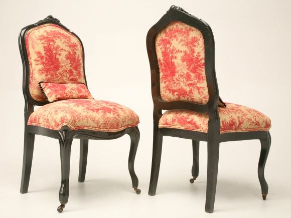 Pair of antique French Napoleon III chairs on casters with red toile upholstery. These chairs have been completely restored with tightened frames, new springs, paddings and upholstery. These chairs are totally awesome. They even have small kidney