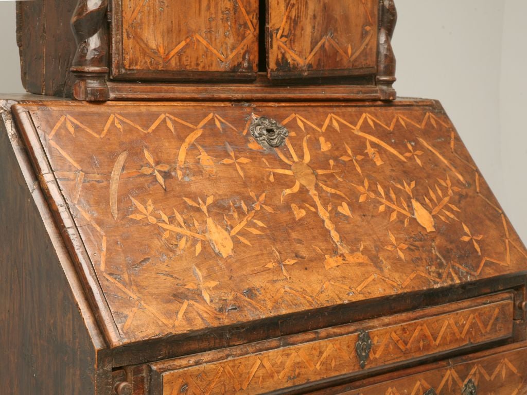 Handmade primitive Spanish desk with extensive inlay. We were told by a European antique expert that this piece is from the 1500's. It has beautiful hand-cut and crude barly twist, family crest pediment and 7 hidden drawers inside. The top exterior