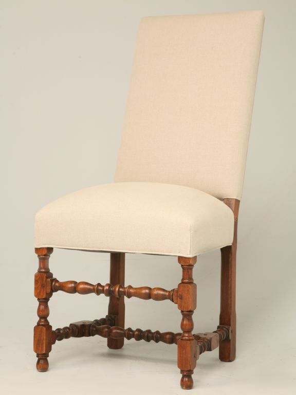 Antique pair of Louis XIII style hand-carved side chairs with beautiful turned stretchers. These chairs has been stripped to its bare frame, disassembled and re-clamped, re-glued and refinished. It received new springs, new padding, new webbing and