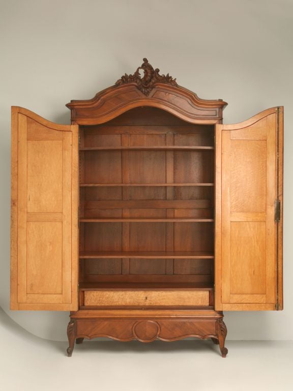 Louis XV style walnut armoire with chevron sides, bird's eye maple on the interior of the doors and a bird's eye maple fitted locking drawer, the original oak shelves, beveled mirror and a hidden drawer on the bottom.