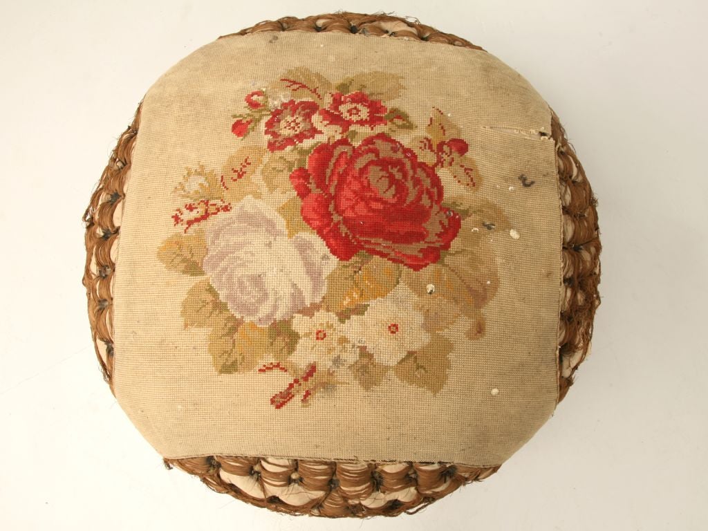 Antique French Victorian needlepoint and silk pouf or ottoman stuffed with horsehair. Made entirely by hand, this outstanding all original pouf is generously oversized. Utilized in the family room for everyone's feet and with a tray for drinks and