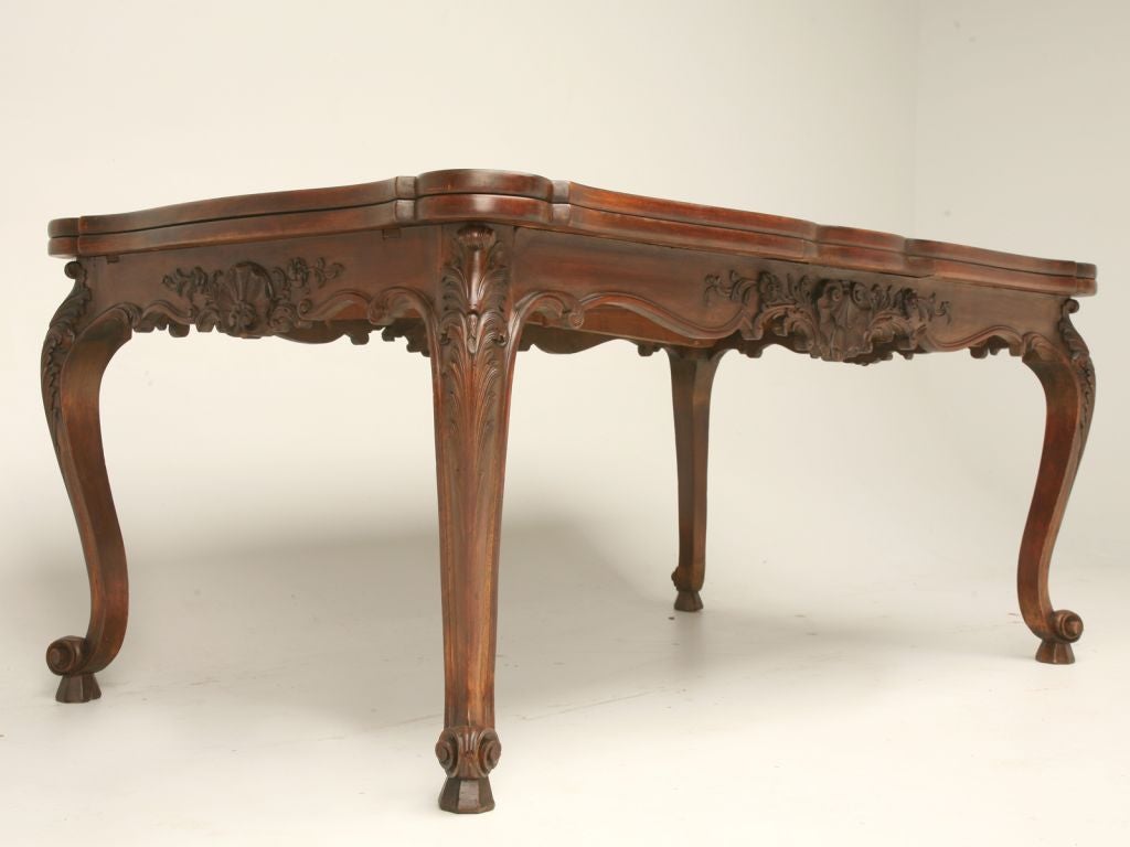 Vintage French dining table made from walnut, cherry and other fruitwood with a beautiful parquet top. The hand-carved detailing will definitely draw anyone’s eye to this piece. From the intricately hand-carved scalloped apron to the cabriolet legs