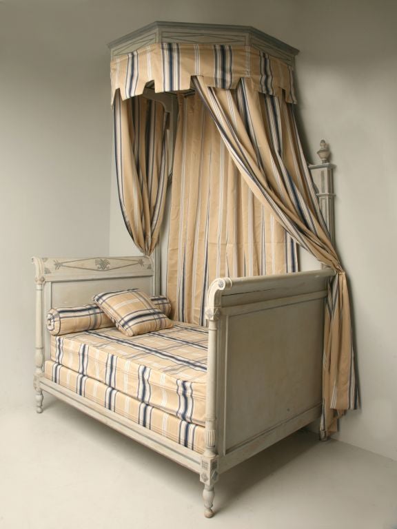 Charming antique French painted Directoire style canopy bed that will make any little girl a princess. Fabric and mattress are new. This bed offers unmistakeable style and breathtaking charm that resonates an heir of quality and distinction. This