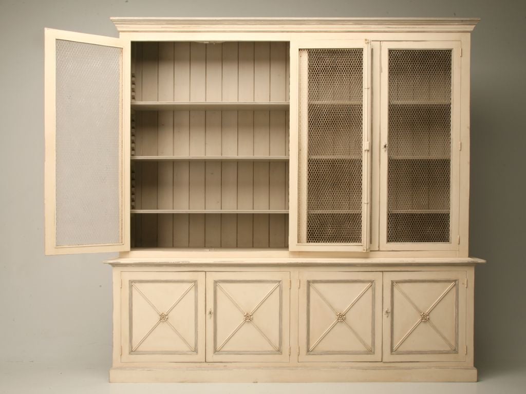 Reproduction bookcase or display cabinet in a Directoire style (1793-1804). Made in England with old timber, a distressed painted finish and antiqued European chicken wire doors. We are now producing these in our workshop in any size or finish.