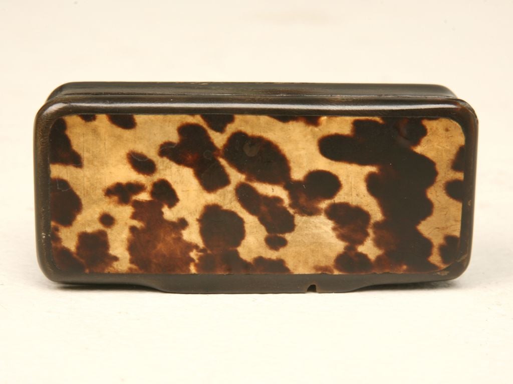 Antique hand carved snuff box with horn body, gentle concave sides and richly grained tortoise veneer lid. A few natural flaws not evidence of damage, but of the natural structure of the horn itself. A great piece to use for your little pill box, or