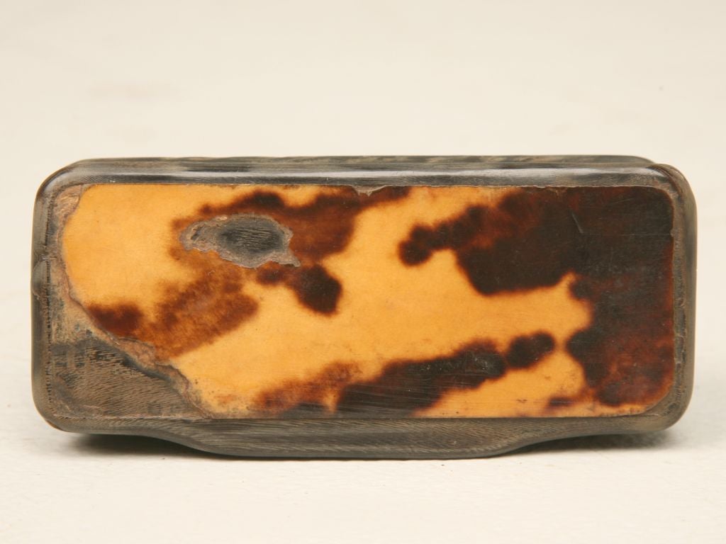 Antique hand carved snuff box with horn body, gentle concave sides and richly grained tortoise veneer lid. There are some natural flaws in the horn that are not evidence of damage, but of the natural structure of the horn itself. The tortoise veneer