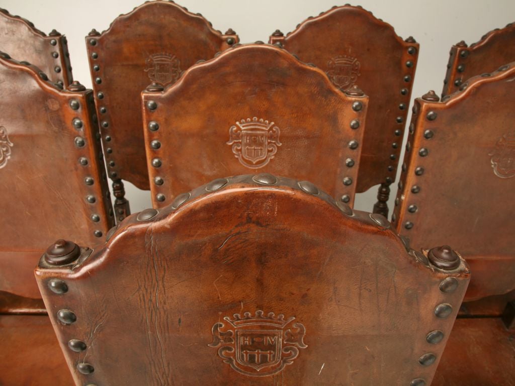 Set of 8 Spanish side chairs made from oak with the original leather. These are nearly impossible to find in a full set in all-original condition.