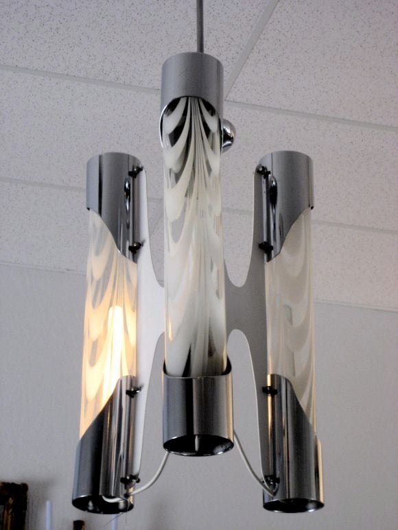 This Vistosi light fixture is a series of three glass tubes encased in chrome. The glass elements are tubular with both white and clear glass. The center armature radiates in three directions and is enameled white.