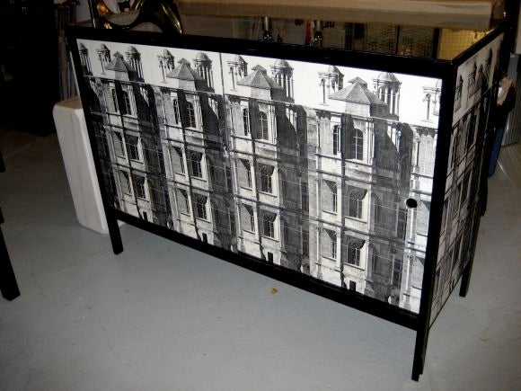 This Faux Fornasetti cabinet was made in Argentina.  The cabinet has paper images of the Duomo. This is a fun piece with storage. The doors slide- opening up to a big space without shelves.